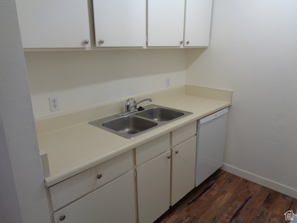 Kitchen with dark hardwood / wood-style floors, white cabinets, white dishwasher, and sink