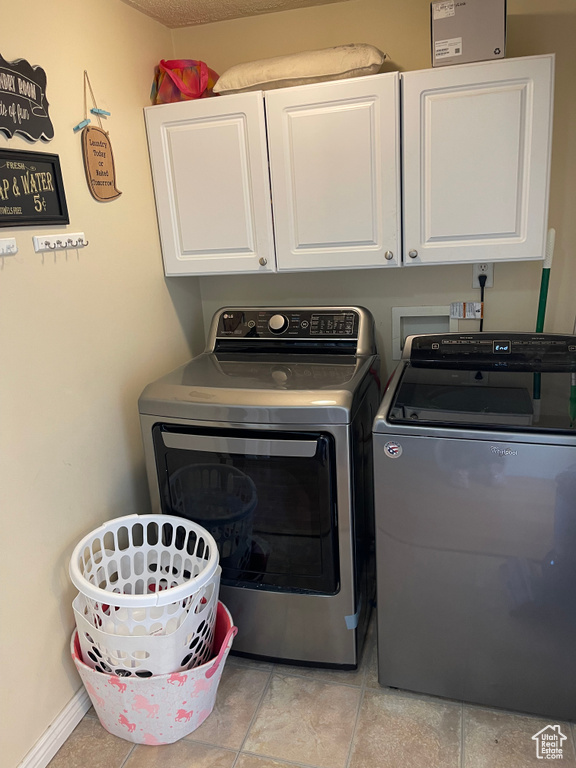 Laundry room with cabinets, washer and dryer, light tile floors, and hookup for a washing machine