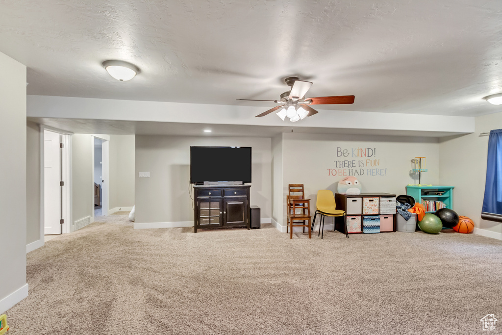 Playroom with ceiling fan and light colored carpet