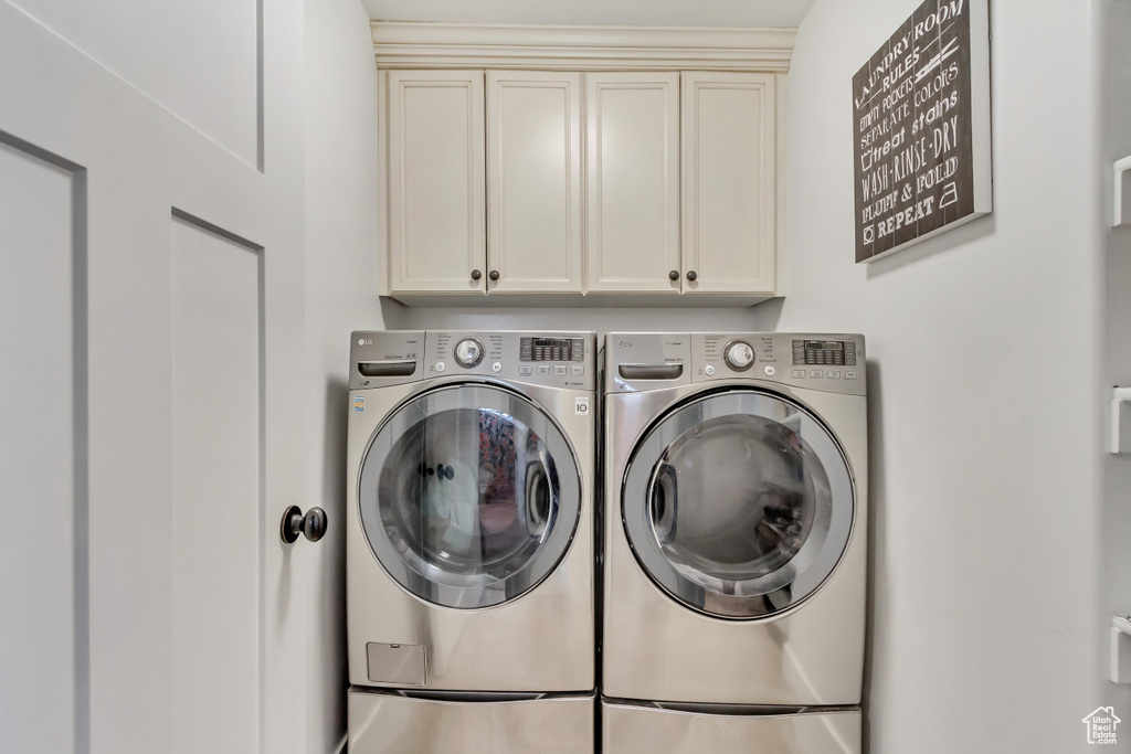 Laundry room with cabinets and washer and clothes dryer