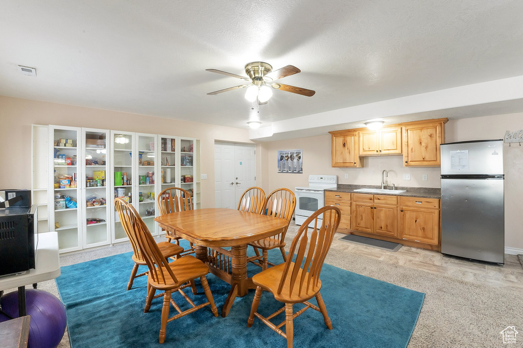 Carpeted dining area featuring sink and ceiling fan