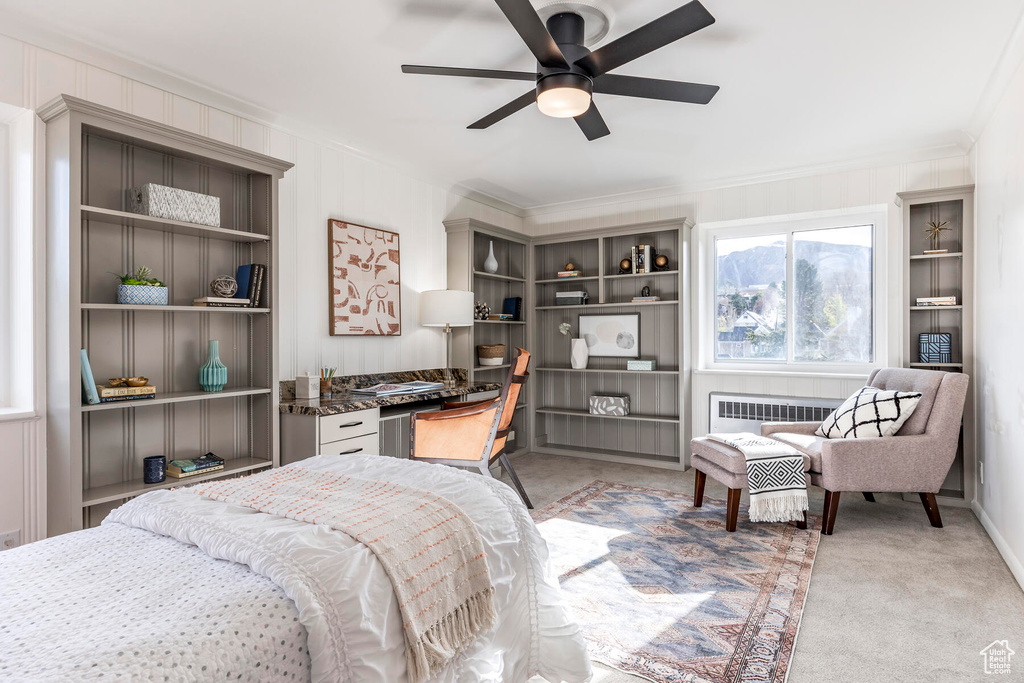 Bedroom featuring light carpet, ceiling fan, ornamental molding, and radiator heating unit