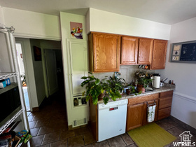 Kitchen featuring dark tile floors and dishwasher