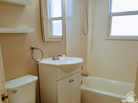 Full bathroom featuring plenty of natural light, toilet, shower / washtub combination, and vanity