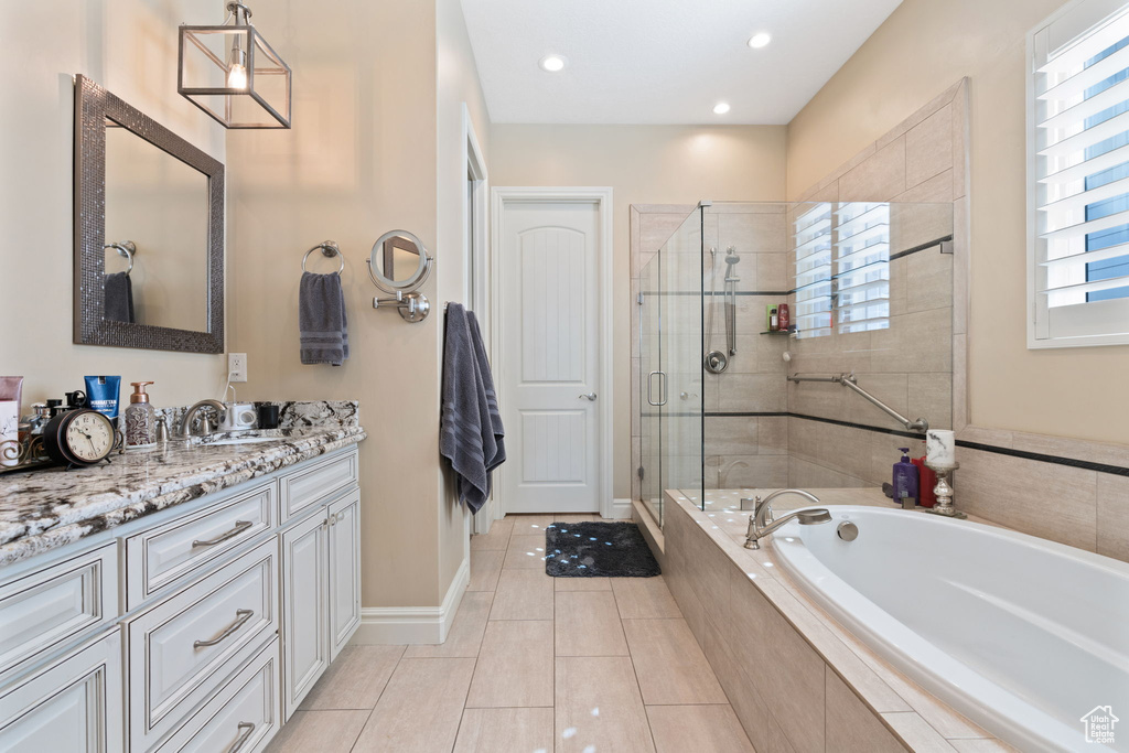 Bathroom featuring tile floors, a wealth of natural light, vanity, and independent shower and bath