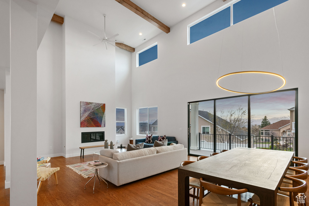 Interior space with ceiling fan, light hardwood / wood-style flooring, beam ceiling, and high vaulted ceiling