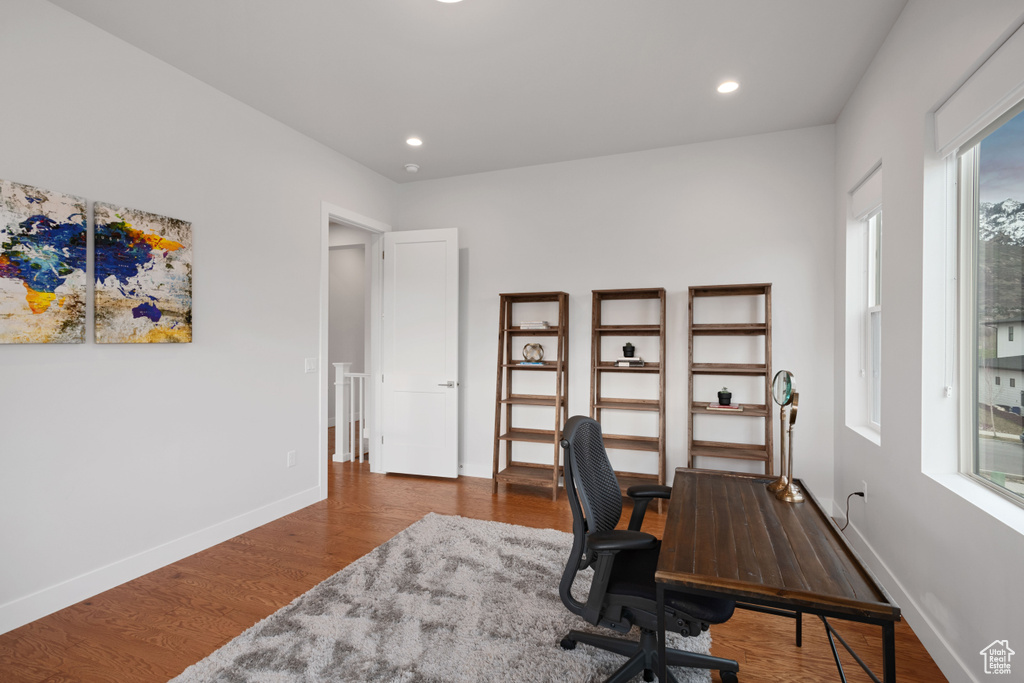 Office with plenty of natural light and dark hardwood / wood-style floors