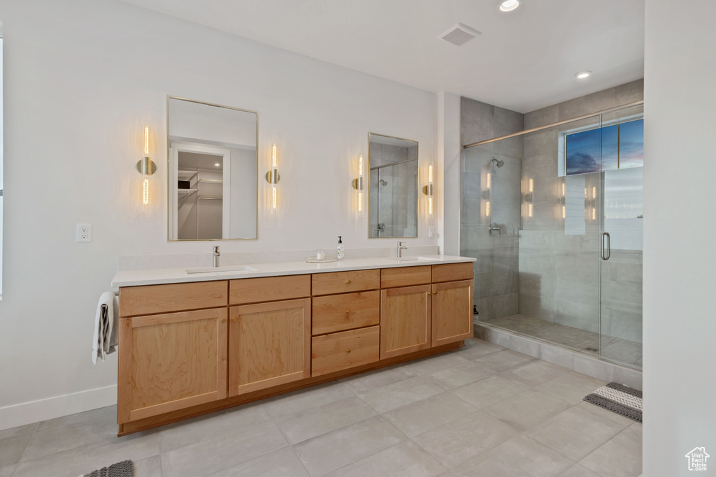 Bathroom with tile flooring, dual vanity, and walk in shower