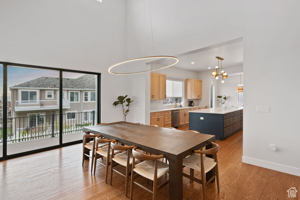 Dining room featuring sink, light hardwood / wood-style floors, a wealth of natural light, and a chandelier
