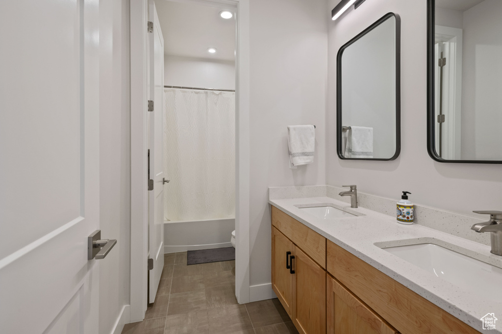 Full bathroom featuring dual vanity, tile flooring, shower / bath combination with curtain, and toilet