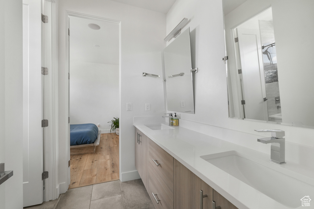 Bathroom with dual sinks, tile flooring, and large vanity