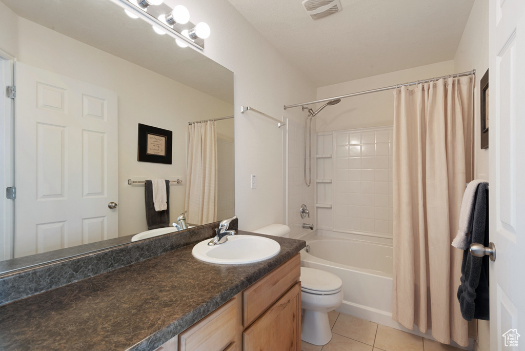 Full bathroom featuring tile flooring, toilet, shower / bath combination with curtain, and vanity
