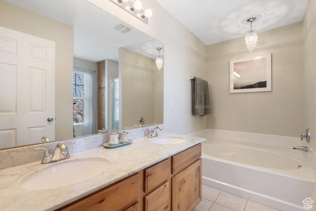 Bathroom with double sink vanity, a bathing tub, and tile floors
