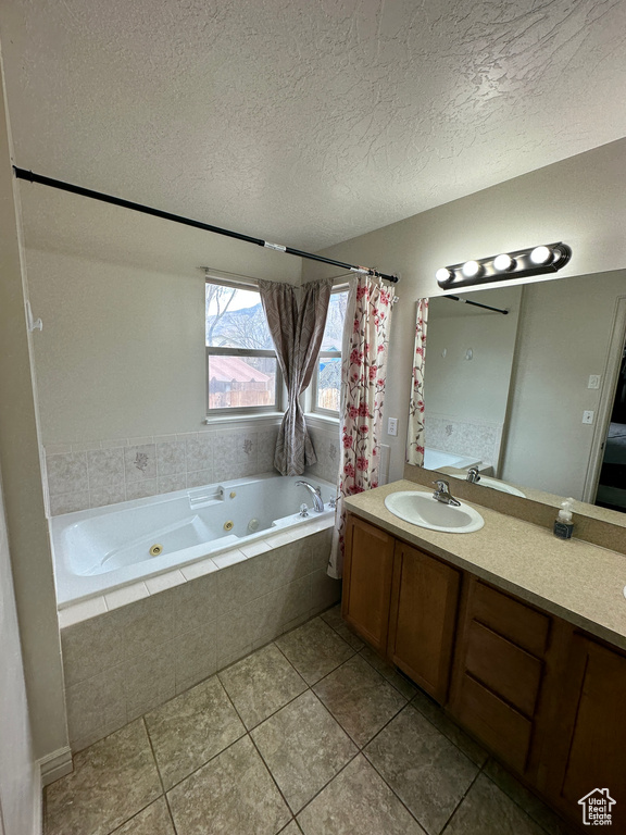 Bathroom with a textured ceiling, large vanity, and tile floors
