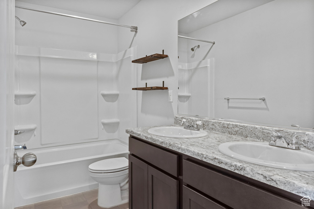 Full bathroom with dual bowl vanity, tile flooring, bathtub / shower combination, and toilet