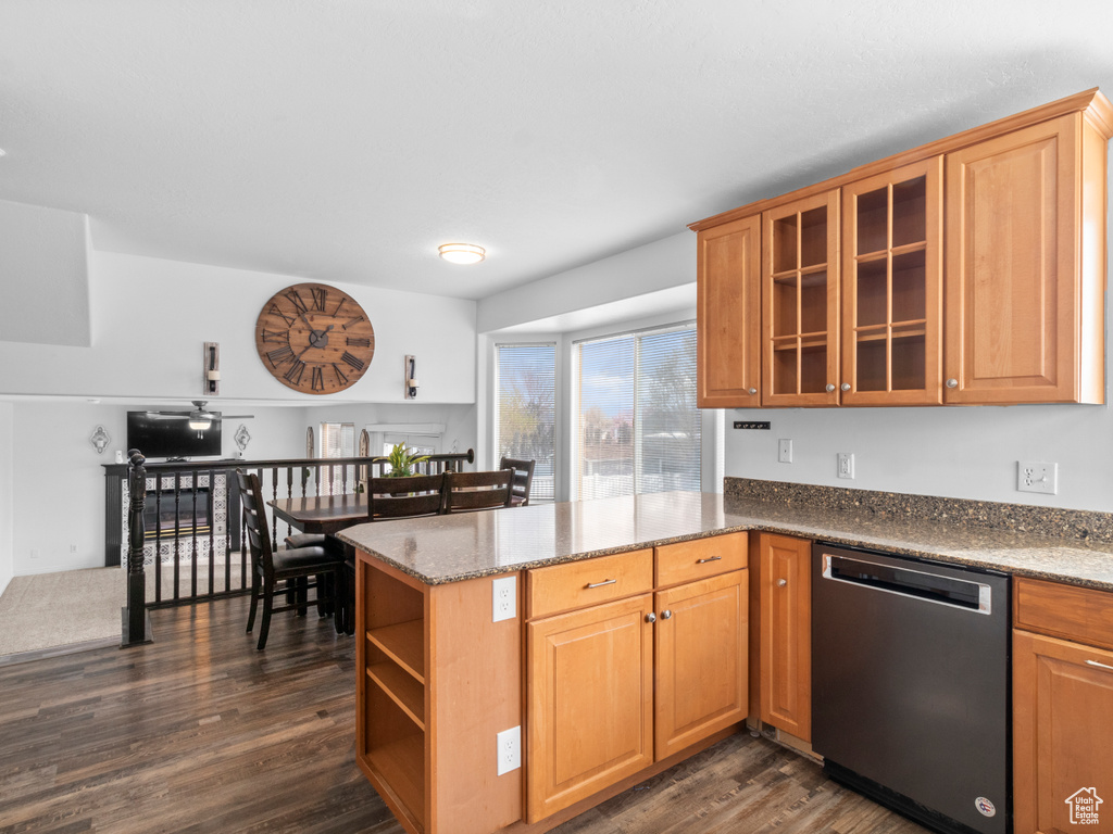 Kitchen featuring stone counters, stainless steel dishwasher, dark hardwood / wood-style floors, and kitchen peninsula