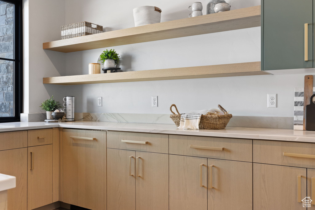 Kitchen featuring light brown cabinetry and light stone countertops