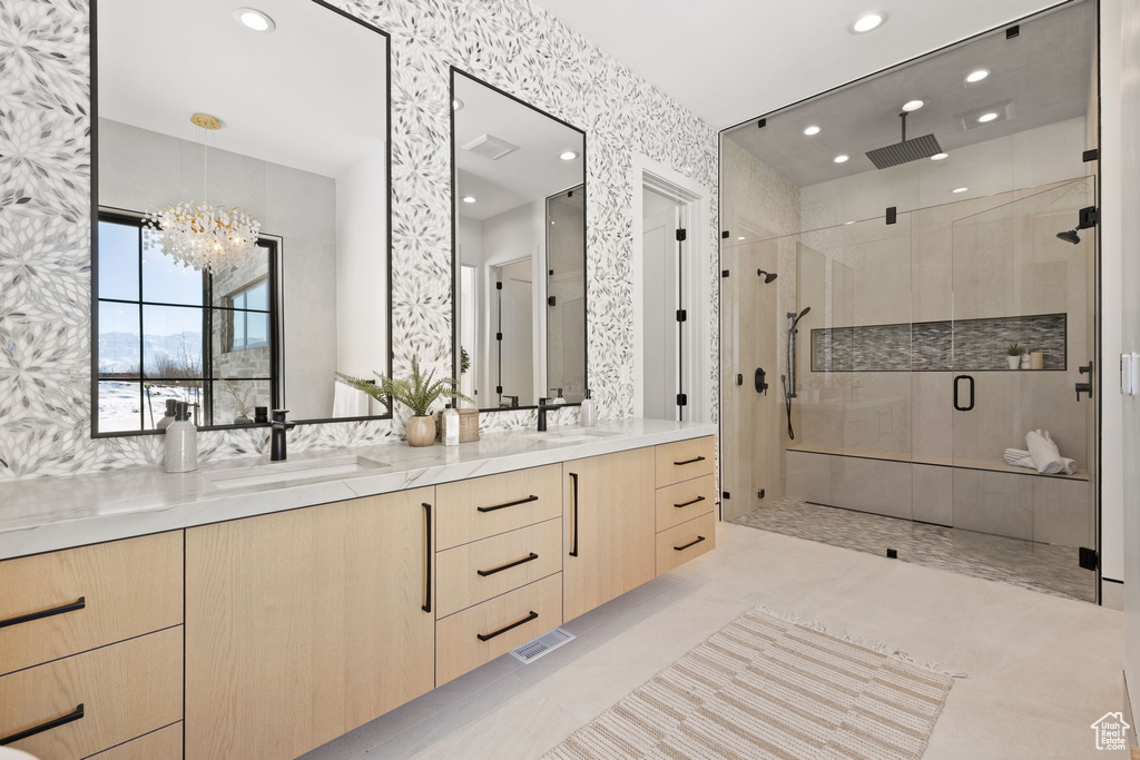 Bathroom featuring walk in shower, tile flooring, a notable chandelier, and dual vanity