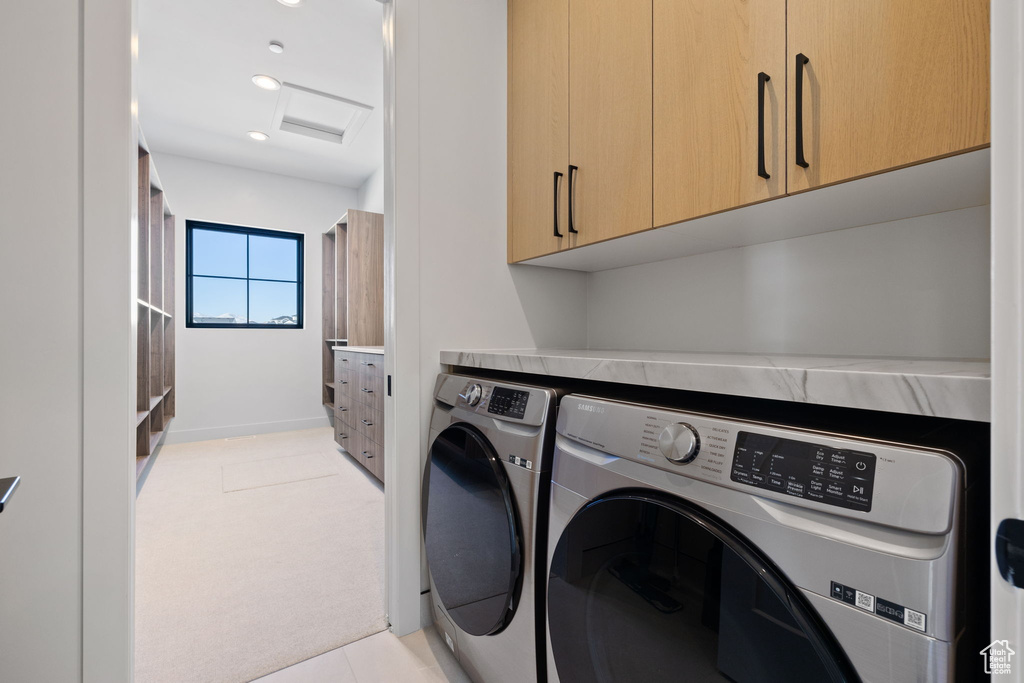 Laundry area with washing machine and clothes dryer, cabinets, and light colored carpet