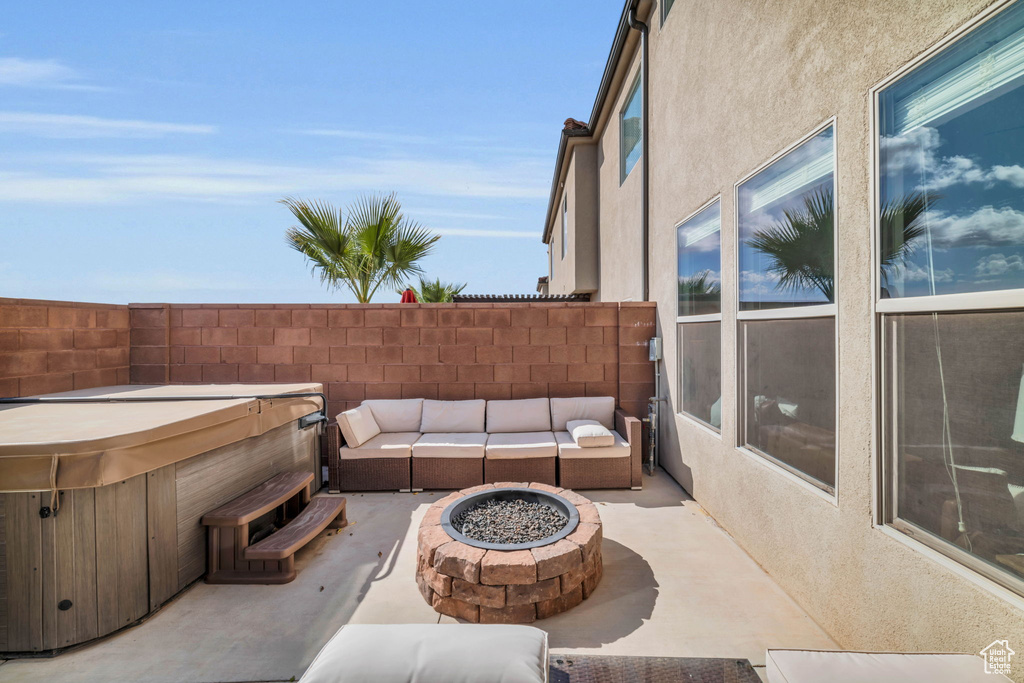 View of patio featuring an outdoor living space with a fire pit and a hot tub