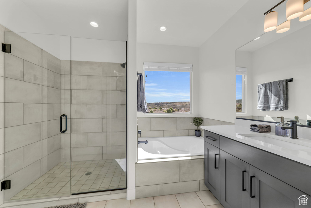 Bathroom featuring oversized vanity, plus walk in shower, and tile floors
