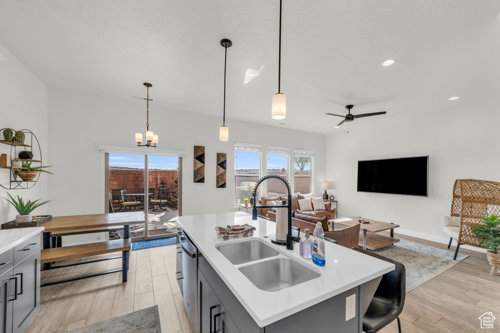Kitchen featuring decorative light fixtures, ceiling fan with notable chandelier, sink, and gray cabinets