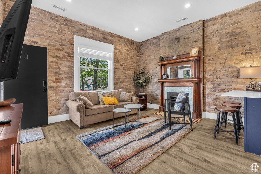 Living room featuring brick wall and hardwood / wood-style flooring