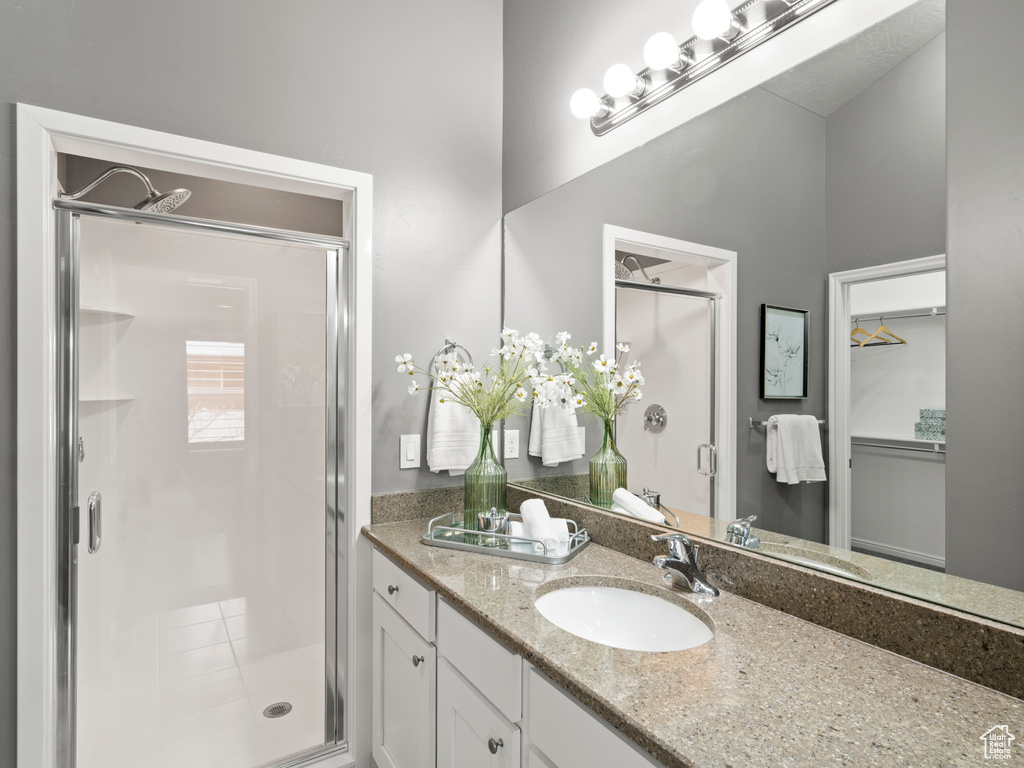 Bathroom featuring an enclosed shower and large vanity