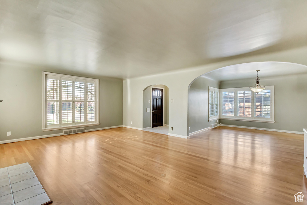 Unfurnished living room featuring light hardwood / wood-style flooring and a wealth of natural light