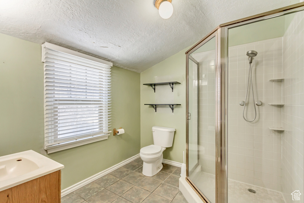 Bathroom with tile flooring, toilet, vanity, and a textured ceiling