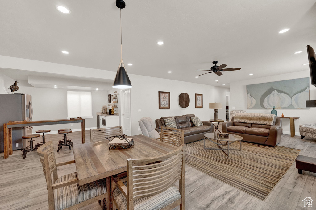 Dining space with light hardwood / wood-style floors and ceiling fan