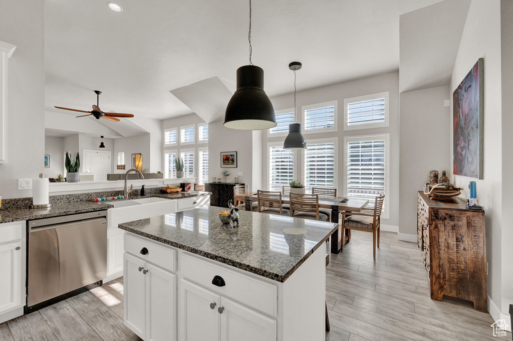 Kitchen featuring dishwasher, white cabinets, a center island, ceiling fan, and pendant lighting