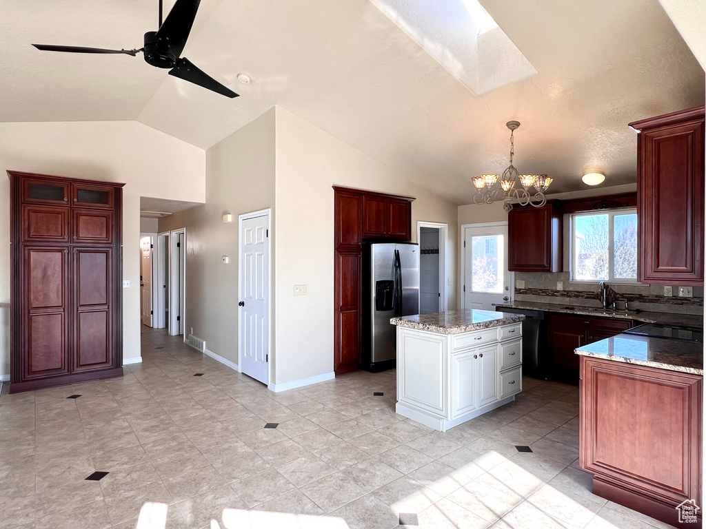 Kitchen featuring ceiling fan with notable chandelier, light tile floors, black appliances, and vaulted ceiling