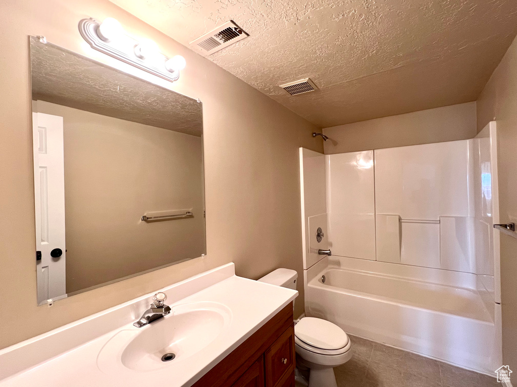 Full bathroom featuring tile floors,  shower combination, toilet, and vanity