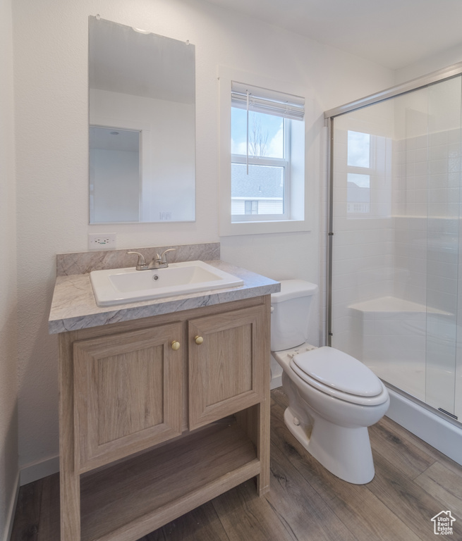 Bathroom with an enclosed shower, toilet, vanity, and hardwood / wood-style floors