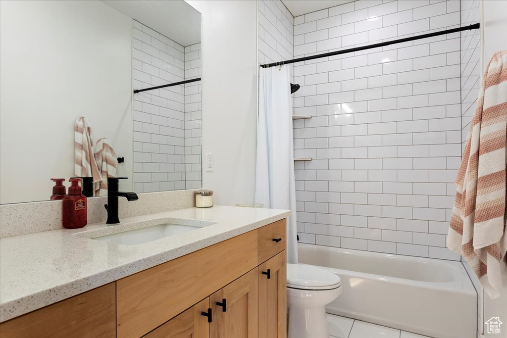Full bathroom featuring tile flooring, toilet, shower / bath combo, and oversized vanity