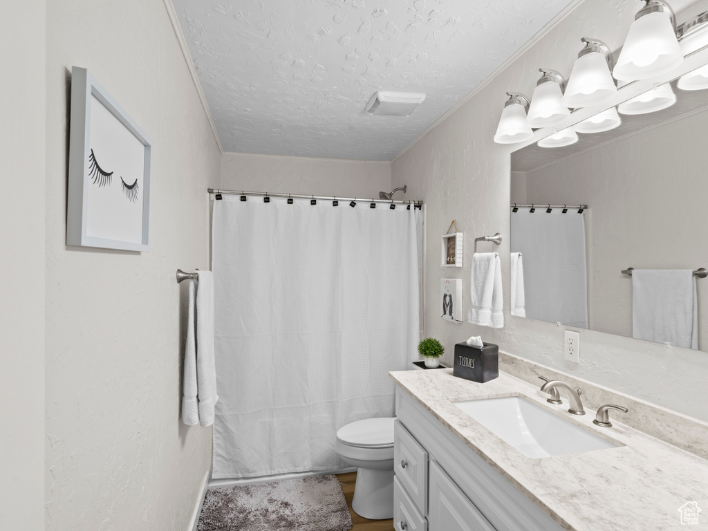 Bathroom with tile floors, toilet, oversized vanity, and a textured ceiling