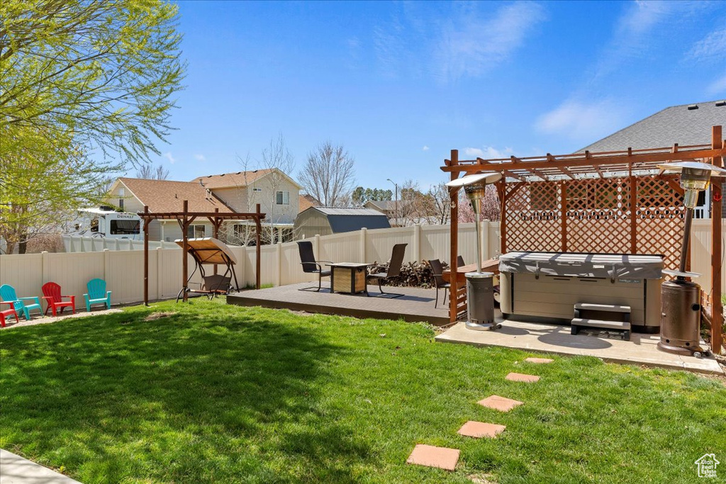 View of yard featuring a patio area, a hot tub, a wooden deck, and a pergola