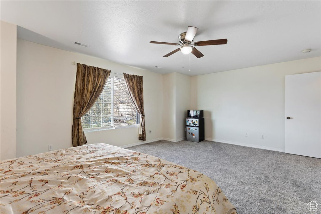 Unfurnished bedroom featuring ceiling fan and light carpet