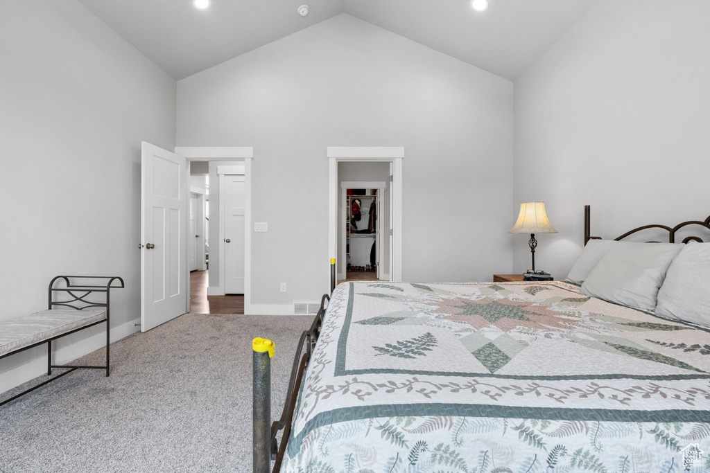 Bedroom featuring high vaulted ceiling and light colored carpet