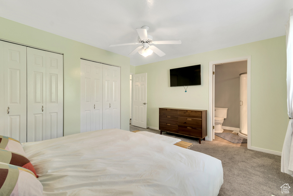 Bedroom featuring light carpet, two closets, ceiling fan, and connected bathroom