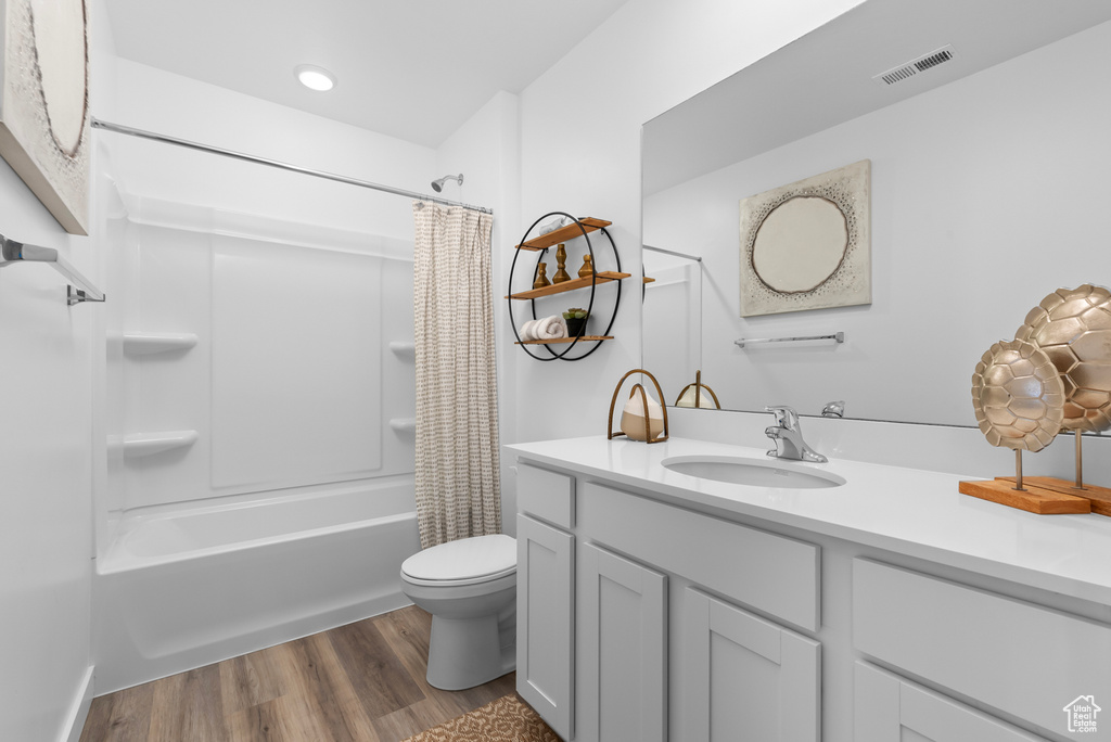 Full bathroom with shower / bath combo, toilet, hardwood / wood-style flooring, and oversized vanity