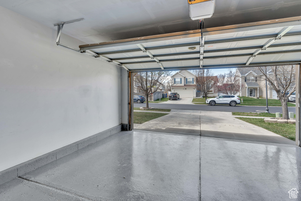 Garage with a lawn, a carport, and a garage door opener