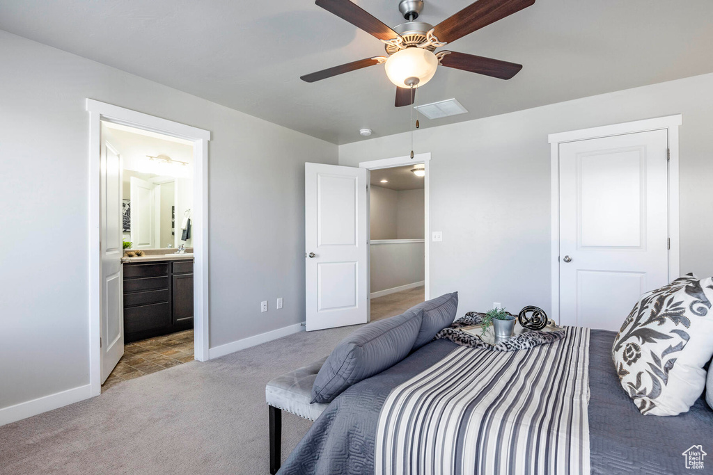 Bedroom with ceiling fan, ensuite bath, and light carpet