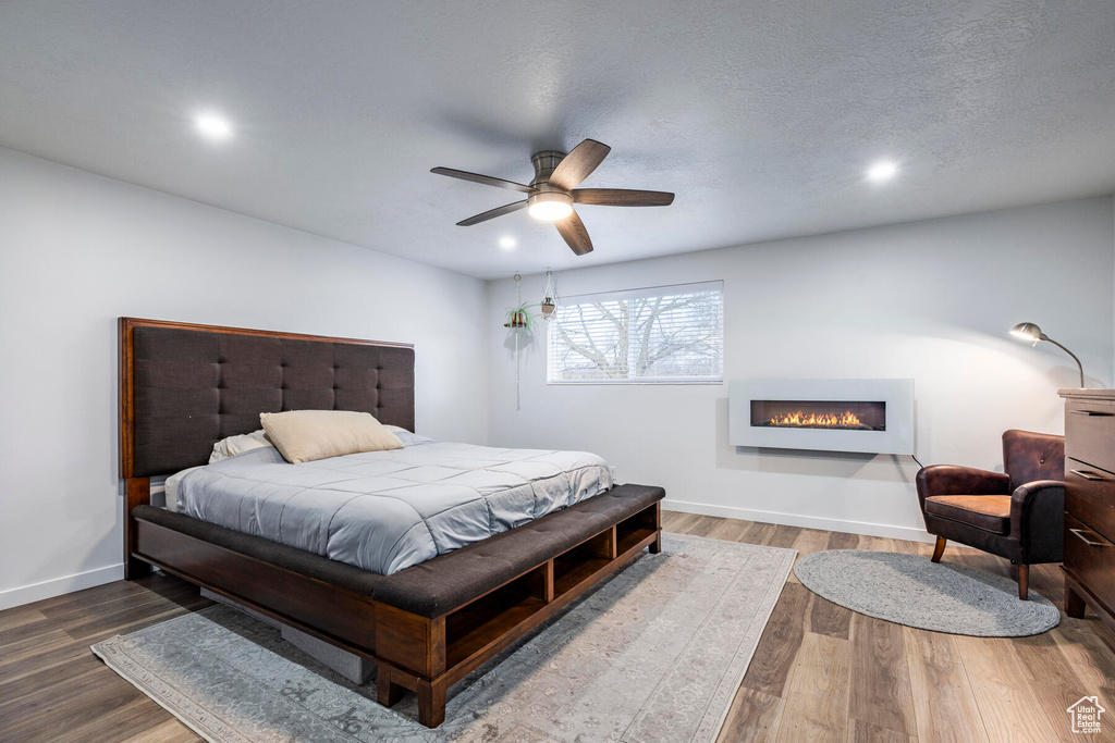 Bedroom featuring a textured ceiling, ceiling fan, and hardwood / wood-style floors