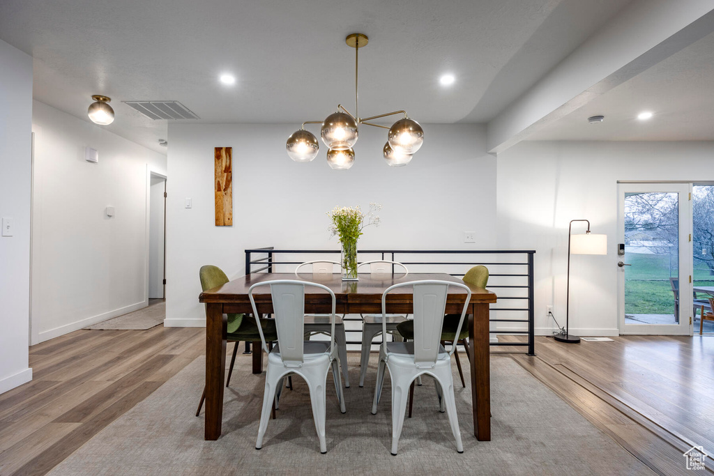 Dining area featuring an inviting chandelier and light hardwood / wood-style floors