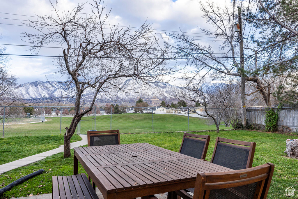 Wooden terrace featuring a lawn and a mountain view