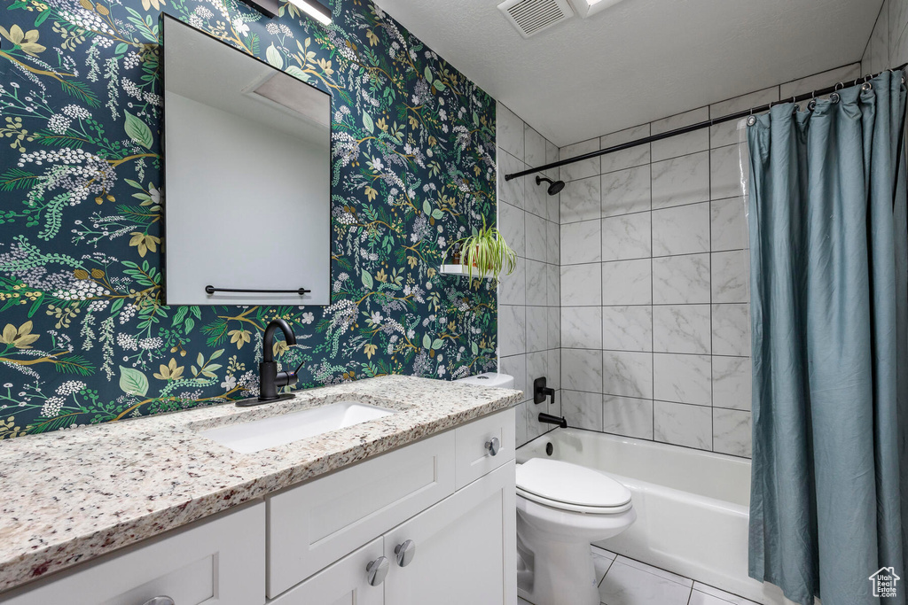 Full bathroom with tile flooring, shower / bathtub combination with curtain, toilet, and vanity