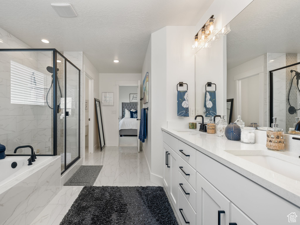 Bathroom featuring separate shower and tub, vanity with extensive cabinet space, tile floors, and double sink