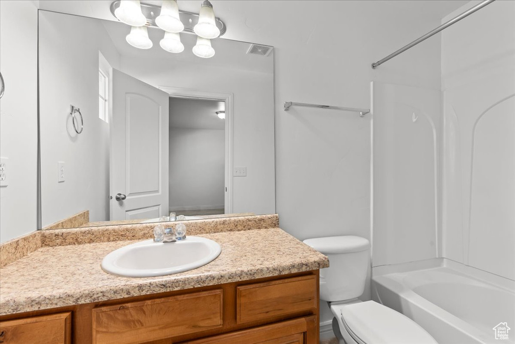 Full bathroom with oversized vanity, toilet, and tub / shower combination